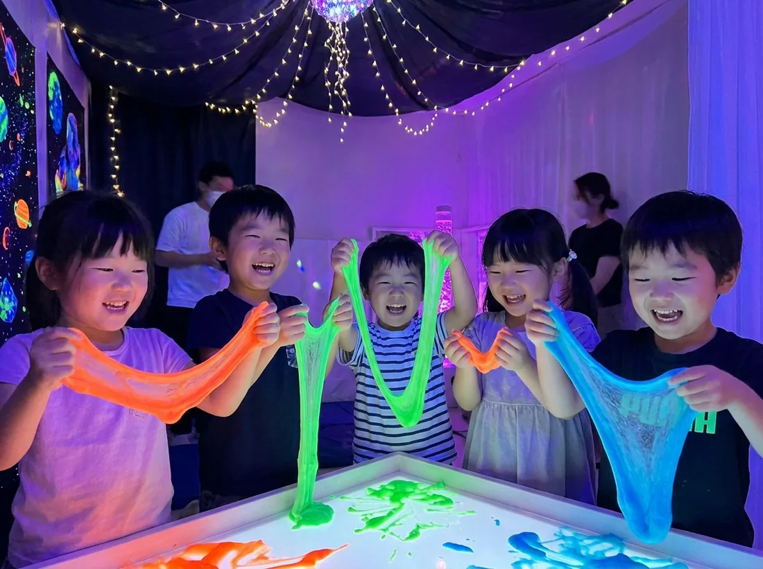 スライムパーク in Kakamigahara で、色とりどりのスライムを伸ばして遊ぶ子どもたち